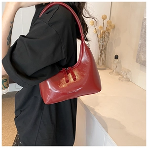 Detail showing red glossy patent leather underarm bag with Fashion & Bags embossed logo