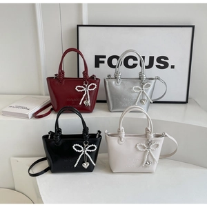 Vue détaillée des sacs seaux brillants en quatre couleurs avec poignées tressées et perles