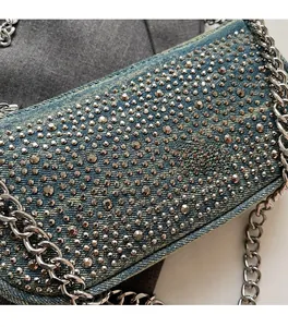 Detail of blue denim shoulder bag with silver rhinestones and heavy metal chain
