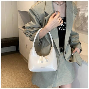 Polished cream half-moon underarm bag styled with a professional sage green blazer