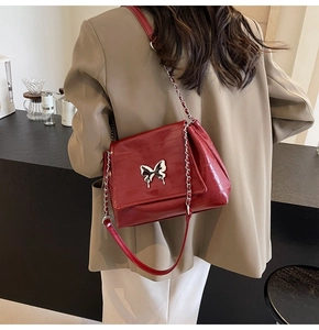 Detailed view of the burgundy embossed leather crossbody bag with silver butterfly buckle