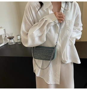 Detailed view of denim crossbody bag with silver rhinestones and metal chain strap