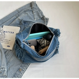 Detail view of denim tote bag showing spacious interior with tablet, phone and wallet