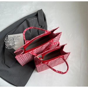 Bovenaanzicht van twee rood-witte canvas tote bags met geometrische bloemen