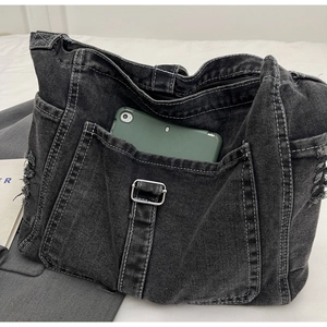 Macro shot showing denim tote interior capacity with a tablet and white contrast stitching