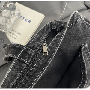 Close-up of vintage washed denim bag featuring metal zipper and internal pocket texture