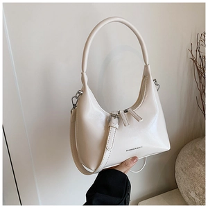 Detailed shot of cream half-moon bag featuring silver hardware and FASHION & BAGS logo