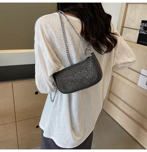 Detail of silver rhinestone shoulder bag with metal chain strap and sparkling crystals