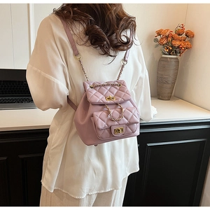 Detail of light purple quilted leather backpack with gold chain straps on a model