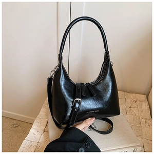 Detail of black glossy crescent bag with white Fashion & Bags text on its surface