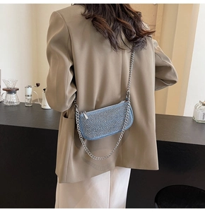 Blue denim rhinestone chain bag shown on model with tan blazer and white trousers