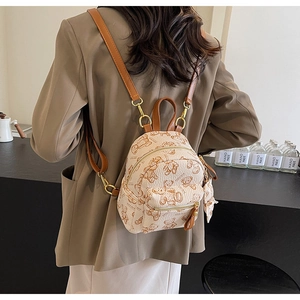Détail d'un mini sac à dos avec motifs d'ours et bretelles réglables en cuir marron