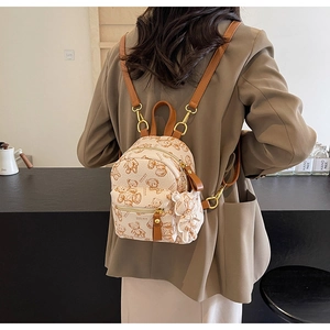 Photo lifestyle d'un mini sac à dos en toile à motif d'ours avec breloque d'ours