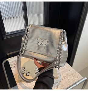 Detail of silver metallic tote with 3D butterfly ornament and chain strap link
