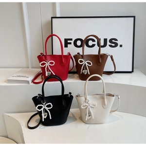 Detailed view of four colorful bucket bags with pearl bow and heart charms