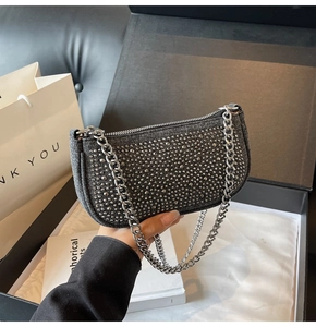 Detail of dark grey hobo bag with silver studs and chain strap in gift box packaging