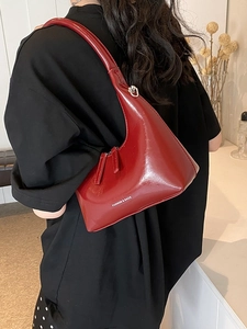 Fashionable dark red crescent underarm bag with gold foil lettering shown on shoulder