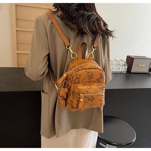 Vue détaillée d'un mini sac à dos marron avec imprimés ours et un pendentif ours