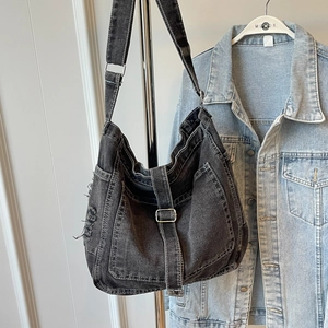 Retro washed denim crossbody bag in black grey with wide strap on display stand