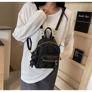 Détail d'un mini sac à dos noir avec motifs d'ours gaufrés et un joli pendentif d'ours