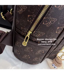 Close-up of golden metal zipper and embossed bear pattern on dark brown leather backpack