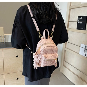 Détail d'un mini sac à dos rose avec motifs d'ours et finitions métalliques dorées
