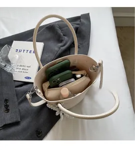 Overhead detail view of beige bucket bag showing spacious interior with pearl charm