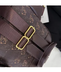 Detail of adjustable metal buckle and woven strap on brown embossed bear pattern backpack