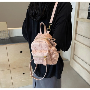 Détail du mini sac à dos rose à motif d'ours avec zip doré et breloque ourson assortie