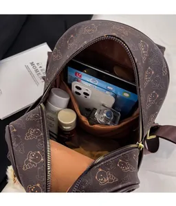 Top-down view of open dark brown backpack showing large capacity for books and tablet