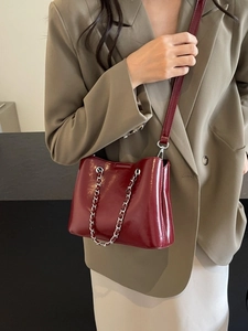 Elegant wine red gloss bucket bag with silver chain detail and slim shoulder strap