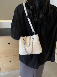 Chic off-white bucket shoulder bag with elegant metal chain strap and leather accents