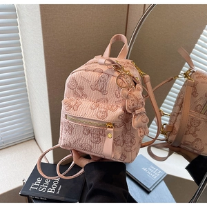 Gros plan du mini sac à dos rose avec imprimés ours et breloque ours assortie