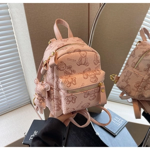 Vue détaillée du mini sac à dos rose avec motifs d'ours et pendentif ours assorti