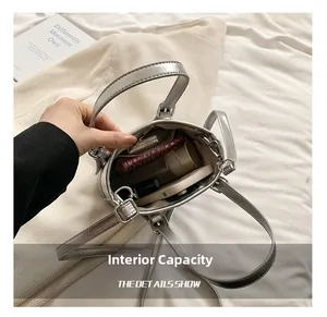 Detail view of the silver bucket bag interior showing capacity for phone and cosmetics