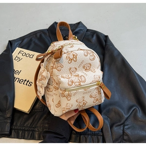 Détail d'un mini sac à dos en cuir avec imprimé ours, texte KEDDY BEAR et pendentif
