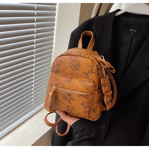 Détail d'un mini sac à dos en similicuir fauve avec imprimé ours et breloque noeud