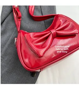 Detail of red glossy bow handbag with comfortable fabric texture and sleek finish