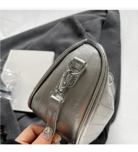 Dettaglio ravvicinato della borsa Boston argento lucido con texture trapuntata e fibbie