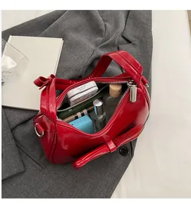 Interior view of red patent leather bow bag showing spacious storage for daily essentials