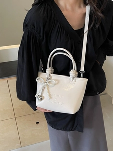 Sac seau beige chic avec breloque nœud en perles et lettrage en relief élégant