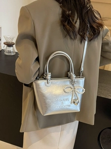 Sac cabas argenté métallisé avec breloque nœud perlé et logo sur mannequin