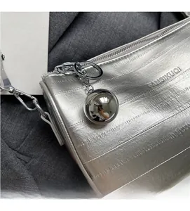 Dettaglio della borsa Boston argento con trama orizzontale e grande ciondolo a sfera cromata