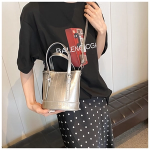 Detail of silver metallic bucket bag with textured faux leather and cylinder handle