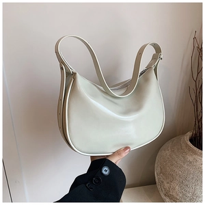 Details einer cremeweißen Halbmond-Schultertasche mit glatter Lederstruktur im Design