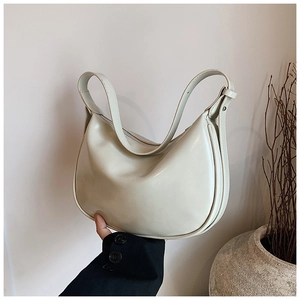 Nahaufnahme der minimalistischen cremeweißen Leder-Hobo-Tasche mit breitem Schultergurt