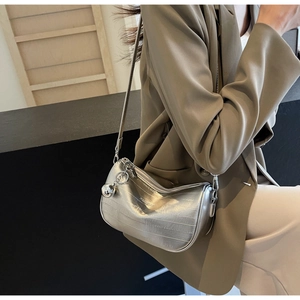 Dettaglio borsa Boston argento con goffratura a righe, logo e ciondolo in metallo