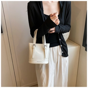 Close-up of white bucket bag featuring metal buckle and FASHION & BAGS logo