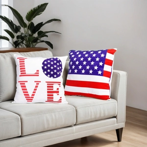 Dettaglio di cuscini decorativi bandiera USA con scritta LOVE su divano grigio