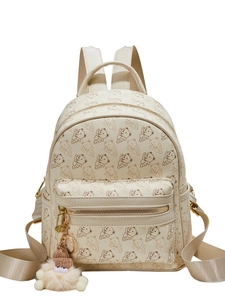 Off-white faux leather backpack with bear print and plush charm on white background